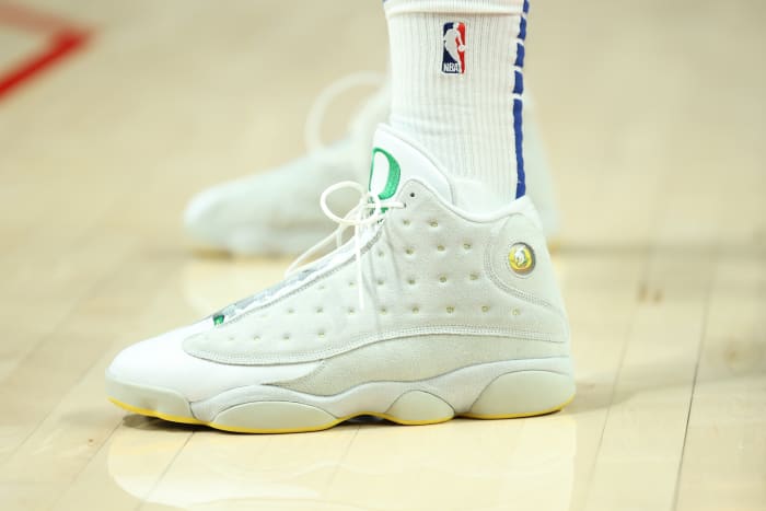 View of white and green Air Jordan shoes.